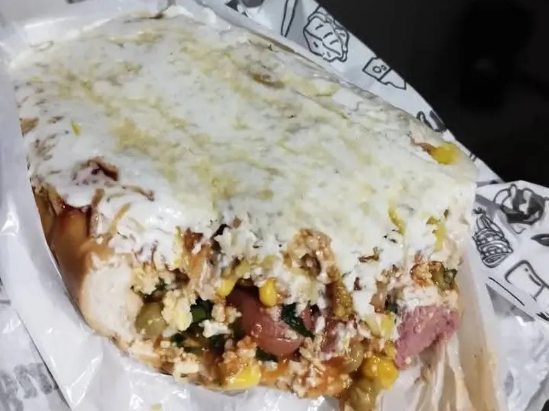 Dog Aberto cortado ao meio mostrando salsicha, milho, ervilha e muito recheio